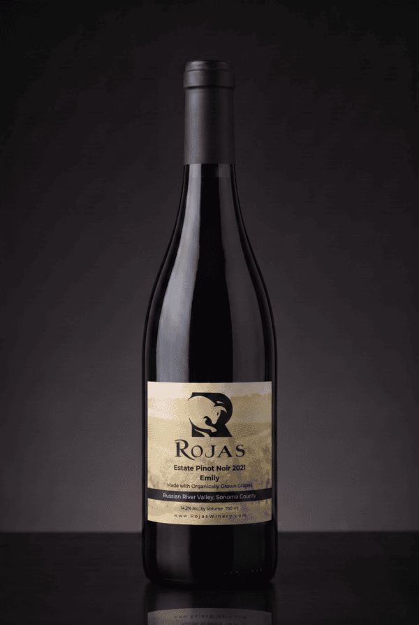A bottle of Rojas Estate Pinot Noir 2021 wine with a black label showing a stylized bird logo, set against a dark, gradient background.