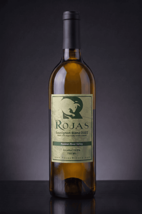 A bottle of Rojas Sauvignon Blanc 2022 wine with a greenish label stands upright on a dark gray background. The label displays the winerys logo and wine details.