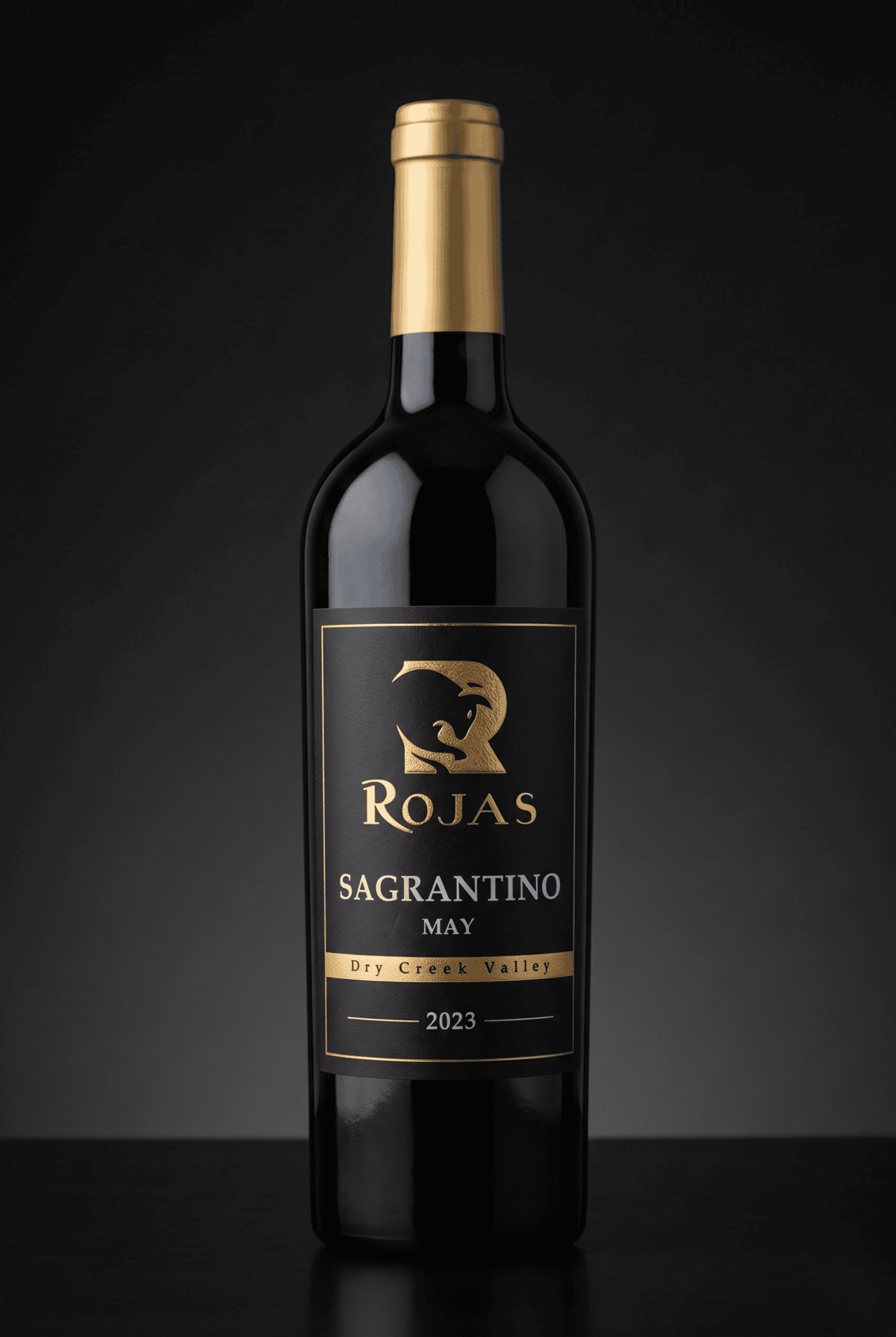 A bottle of Rojas Sagrantino wine, vintage 2023, with a gold label and cap. The label reads Dry Creek Valley and features a stylized animal logo. The background is dark and plain.