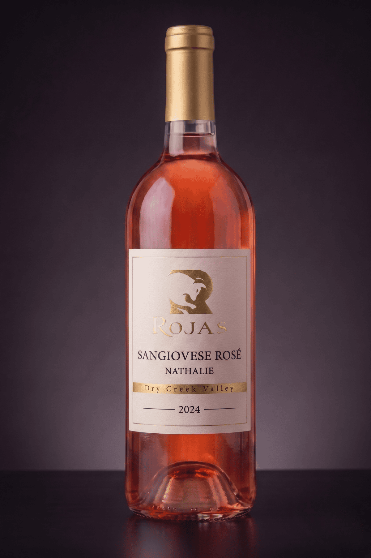 A bottle of Rojas Sangiovese Rosé wine from Dry Creek Valley, vintage 2024, with a gold cap and a gold-accented label on a dark background.